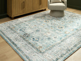 Bay Furniture Gallery - Ashley Furniture - Ladstoney Rug - 7'6" x 9'6" Area Rug / Teal/Beige/Ochre - R407501